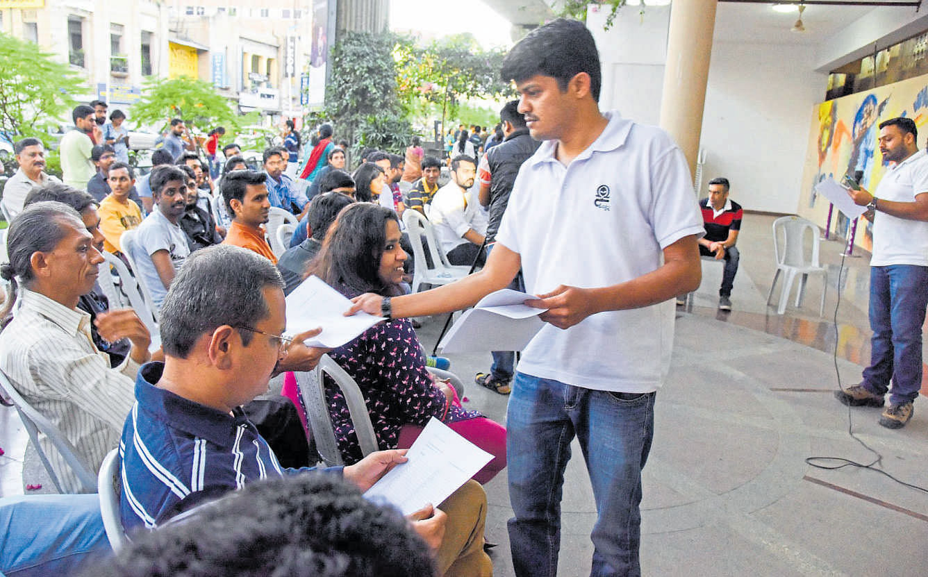 The staff of kannadagottilla.com tutorial distribute Kannada-learning material to people at an event called 'Anybody can teach Kannada - Namma Bhashe' at Rangoli Metro Art Center in the city on Sunday. DH Photo