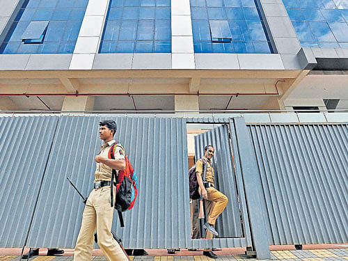 Policemen come out of one of the closed call centres in  Mira-Bhayander, on the outskirts of Mumbai, on Thursday. REUTERS