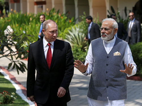 Russian President Putin and India's PM Modi walk during their meeting in Benaulim. Reuters Photo.