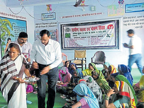 Ashok Prajapati distributes nutritious food to pregnant women at Pareshra village in Uttar Pradesh during a function.