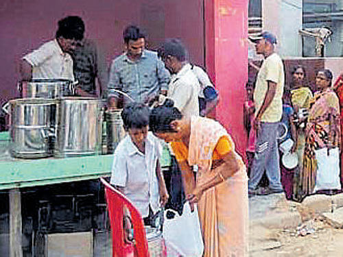 People wait to collect food at a distribution centre in city.