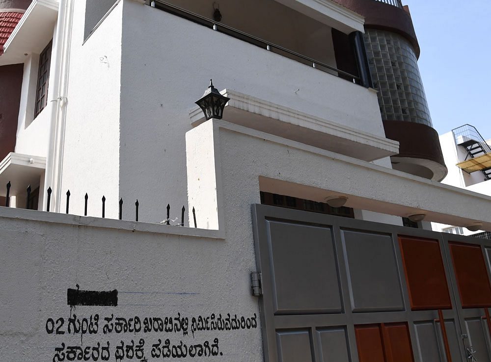 The notice written on the compound wall of Kannada actor Darshan's house in Rajarajeshwari Nagar on Saturday, proclaiming government's takeover of the building. DH photo