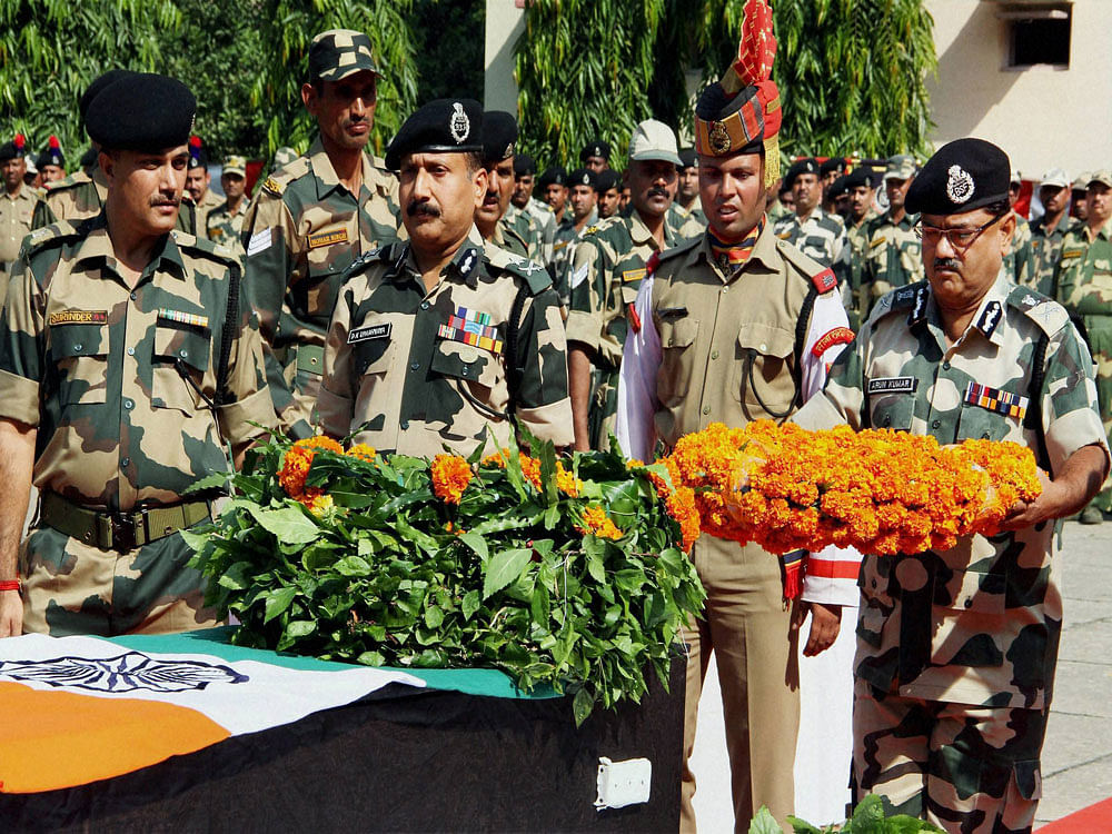 Additional DG, BSF, Arun Kumar paying floral tribute to BSF Constable Gurnam Singh who lost his life in firing by Pakistan, during a wreath laying ceremony at BSF's Paloura Camp in Jammu on Sunday. PTI Photo