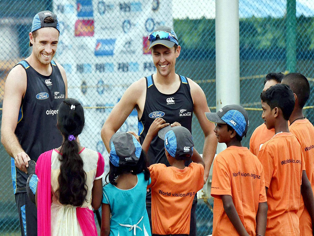 New Zealand cricketers Tim Southee and Trent Boult meeting with underprivileged children at a practice session in Vishakapatnam on Friday ahead of the fifth ODI against India. PTI Photo