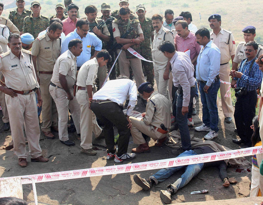 Police investigate the encounter site at the hillocks of Acharpura village after the STF killed 8 Students of Islamic Movement of India (SIMI) activists who escaped Central Jail killing a security guard in Bhopal on Monday. PTI Photo