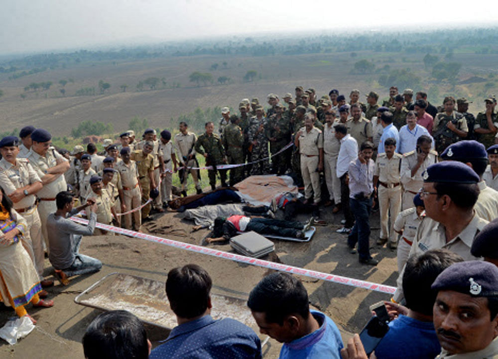 Police officers and STF soldiers stand beside dead bodies of the suspected members of the banned SIMI, who earlier today escaped the high security jail in Bhopal, and later got killed in an encounter at the Acharpura village. Reuters