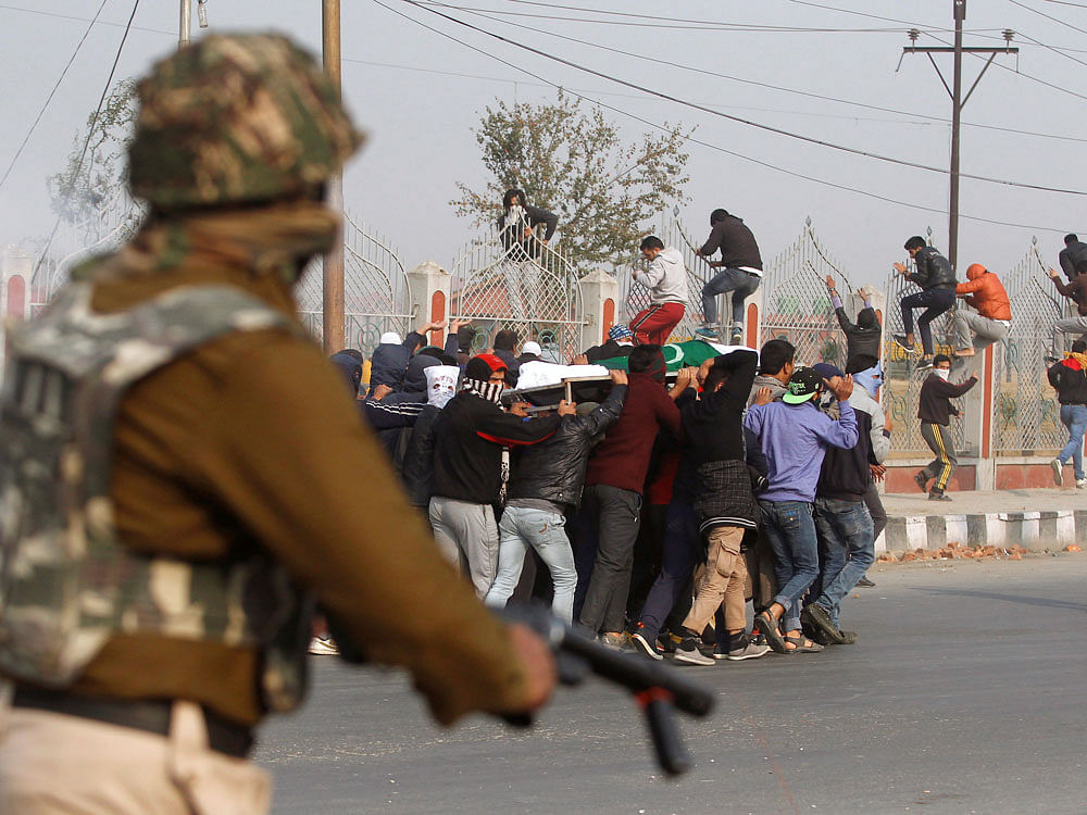 People carrying the body of Qaiser Sofi run as they are chased by Indian police during his funeral in Srinagar. Reuters Photo