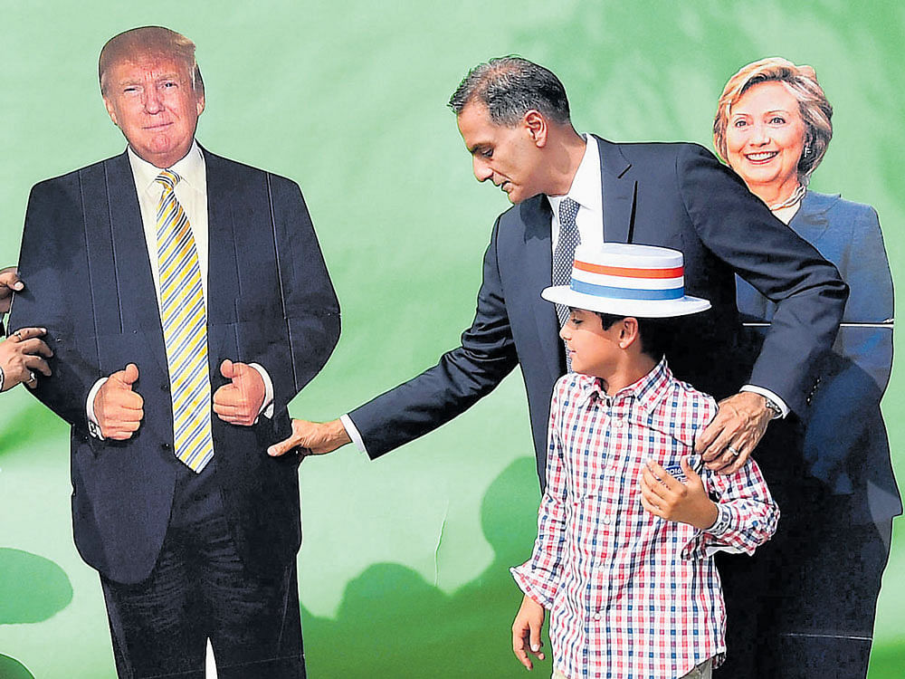 USAmbassador to India Richard Verma and his son pose with cutouts of US presidential candidates Donald Trump and Hillary Clinton at his residence inNewDelhi on Wednesday. PTI