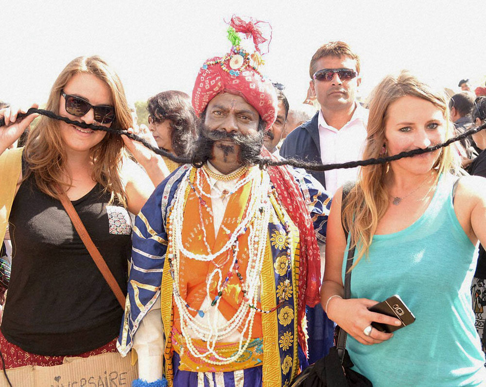 Foreign tourists enjoying at Pushkar Camel Fair in Pushkar on Saturday. PTI Photo