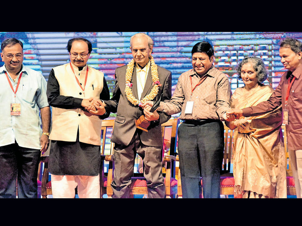 (From left) Suresh Urs, Nagathihalli Chandrashekhar, Rajan, Basant Kumar Patil, Harini and Baraguru Ramachandrappa greet each other after receiving the state film awards for 2014 and 2015 in Bengaluru on Sunday. DH&#8200; photo