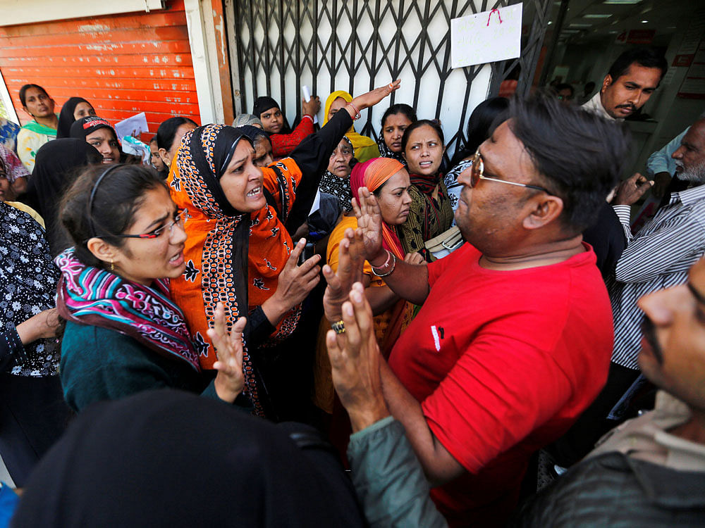 Women argue with employees of a bank in Ahmedabad on Wednesday. REUTERS