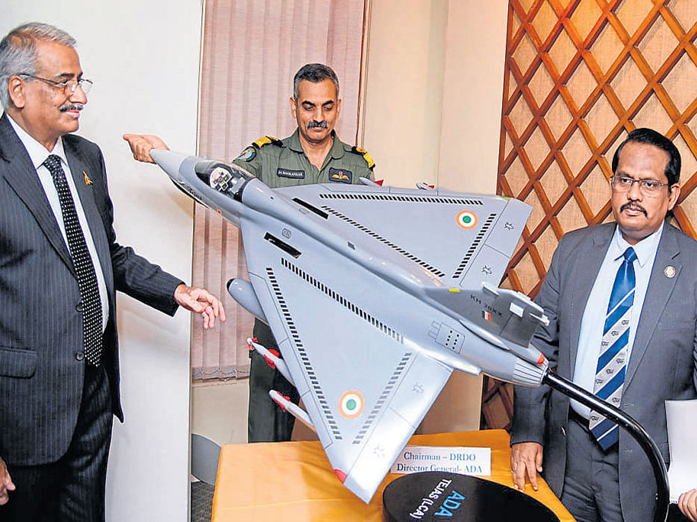 Air Cdre C D Balaji (retired), director of the Aeronautical Development Agency; J&#8200;A Maolankar, chief test pilot of the National Flight Test Centre; S Christopher, director general of DRDO, look at a model of the light combat aircraft Tejas at a press conference in Bengaluru on Sunday. dh photo