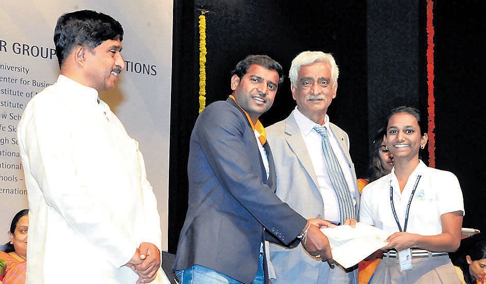 POIGNANT MOMENT(Froml eft) K C Ramamurthy, chairman, CMR Group of Institutions; HN Girisha, paralympic medal winner; and trustee K C Raju Reddy, awarding a sports scholarship to S Joshna, a student of CMR National PU College.