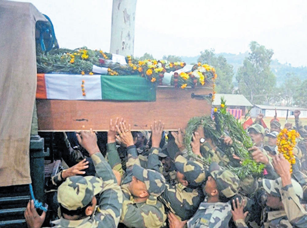 BSF officers carry the coffin of head constable Rai Singh who lost his life in ceasefire violation by Pakistan, during a wreath laying ceremony in Rajouri on Monday. PTI