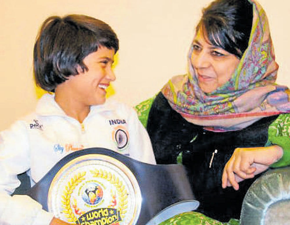 J&K Chief Minister Mehbooba Mufti interacts with eight-year-old Tajamul Islam. PTI.
