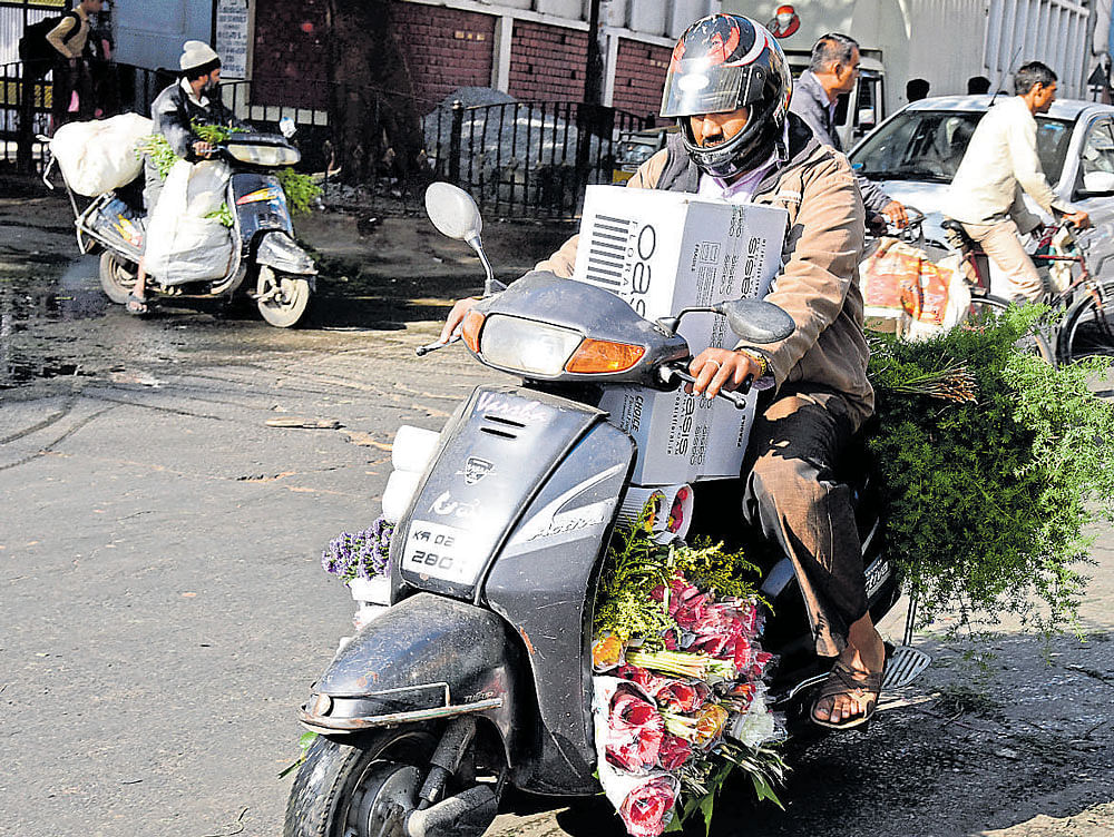 Two-wheeler riders with a heavy load pose a risk to other road users. DH PHOTO BY SK DINESH