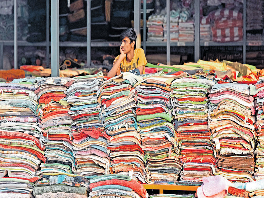 NO TAKERS: A carpet vendor waits for customers. Unless the Modi's government is able to get the informal sector back on its feet, India's growth will be slowed sharply next year, economists say, counteracting the gains he sought to achieve from the currency ban. DH PHOTO