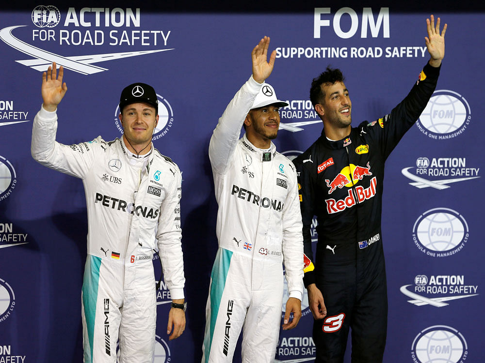Mercedes' Formula One drivers, Lewis Hamilton of Britain (C), Nico Rosberg of Germany (L) and Red Bull Formula One driver Daniel Ricciardo of Australia (R) line up for group photo after winning the pole position at qualifying session. Reuters Photo.