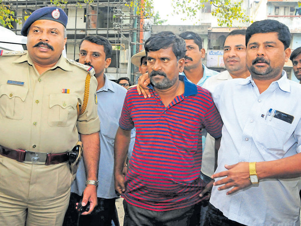 Police escort Dominic Selvaraj Roy, the cash van driver, to the Upparpet station after his arrest on Tuesday. DH Photo