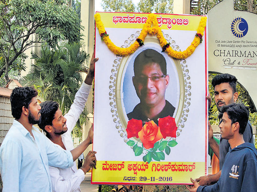 Local residents place a portrait of Akshay at the entrance of Jade Garden, a gated communitywhere his family lives, at Sadahalli on International Airport Road on Tuesday and pay their tributes