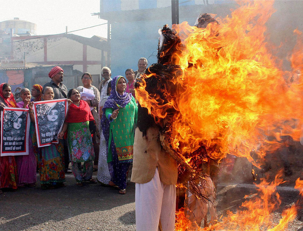 People burn the effigies of Union Carbide, Prime Minister Narendra Modi and Madhya Pradesh Chief Minister Shivraj Singh Chouhan during a demonstration in front of the Union Carbide Factory on 32nd anniversary of Bhopal gas disaster in Bhopal on Saturday. PTI Photo