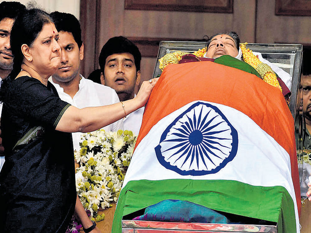 Jayalalithaa's close confidant Sasikala stands near the coffin. PTI