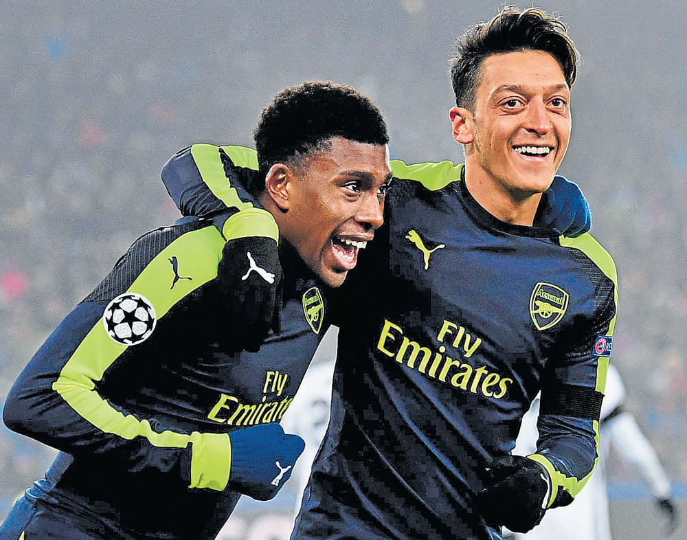 teamwork Arsenal's Alex Iwobi (left) celebrates with Mesut Ozil after scoring against FC&#8200;Basel during their Champions League fixture on Tuesday. AFP