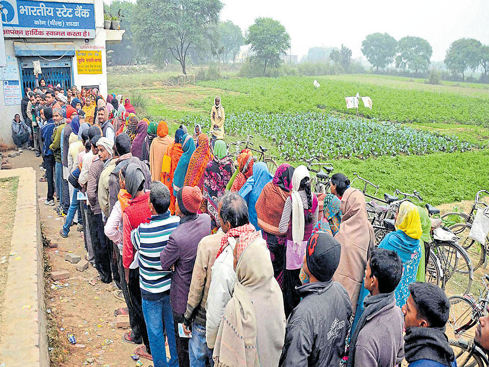 People line up in front of an ATM in Mirzapur on Thursday. PTI