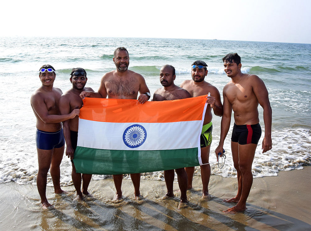 Swimmers from Seat Hawks exult in joy after reaching Tanneerbhavi beach in Mangaluru on Thursday. Swimmers wing commander Paramveer Singh, A16-year-old boy studying in class eleven Manav Mehta, Indian Airforce (IAF) Vicky Tokas, Assistant sub-inspector of police Shrikant Palande, Ex-IAF Gulupili Narahari are seen. DH Photo/Govindraj Javali