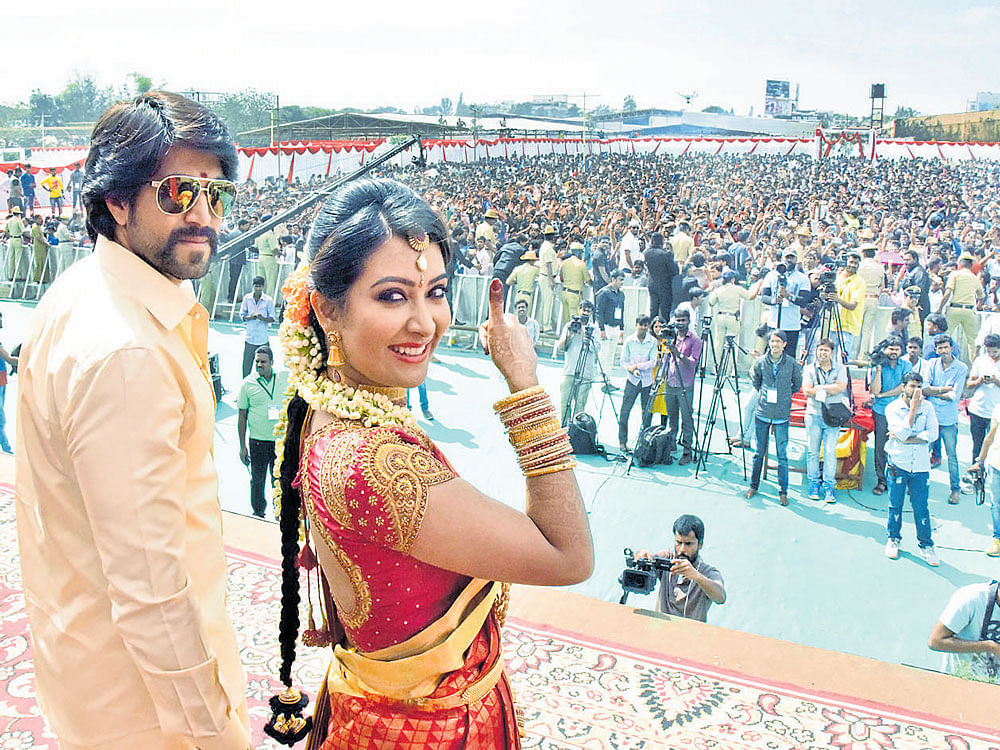 Radhika Pandith shows the thumbs-up sign as Yash looks on during the reception hosted by the star couple for their fans at the Palace Grounds in Bengaluru on Sunday. dh photo