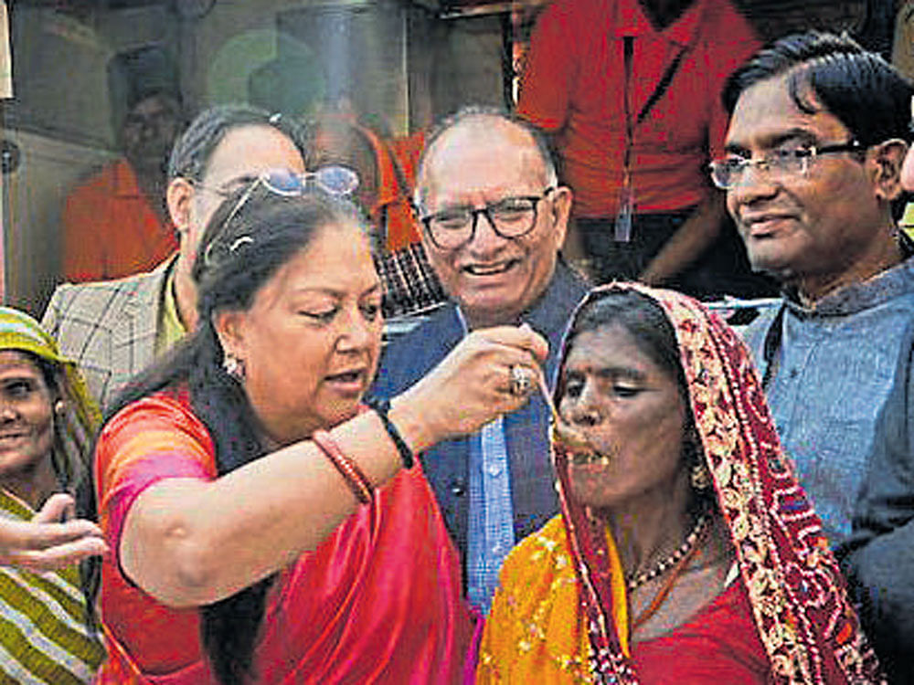 Rajasthan Chief Minister Vasundhara Raje feeds a woman at an Annapurna Rasoi in Jaipur on Thursday.