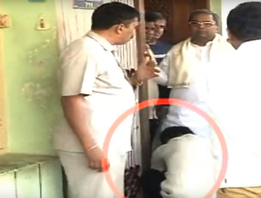 A&#8200;video grab of what appears to be Chief Minister Siddaramaiah's personal assistant Kumar helping him wear shoes, when the former visited actor Chetan Rama Rao's house in Mysuru to pay his last respects to the actor on Saturday.