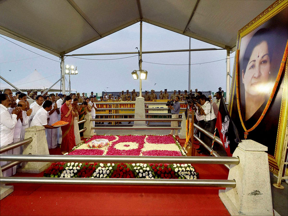 Newly appointed AIADMK General Secretary V K Sasikala pays tribute to late J Jayalalithaa at her burial spot in Chennai on Friday. Tamil Nadu Chief Minister O Panneerselvam is also seen. PTI Photo