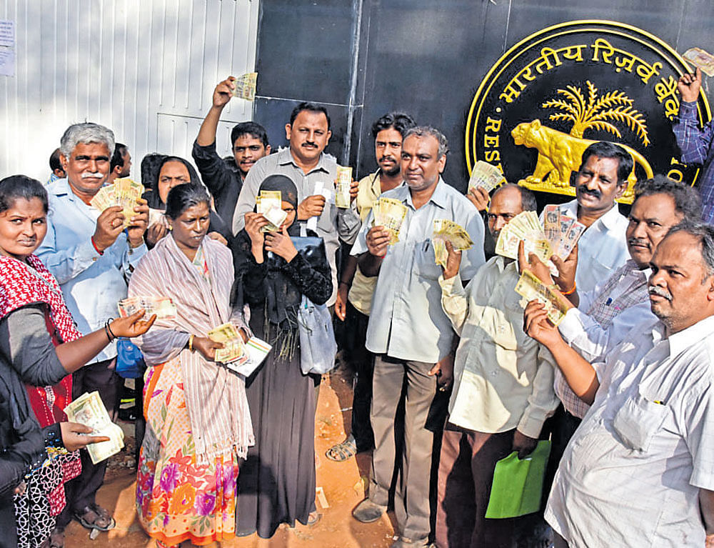 People who came to the Reserve Bank of India on Nrupathunga Road on Monday to exchange the banned currency show the old Rs 500 and Rs 1,000 notes in their possession. DH&#8200;Photo