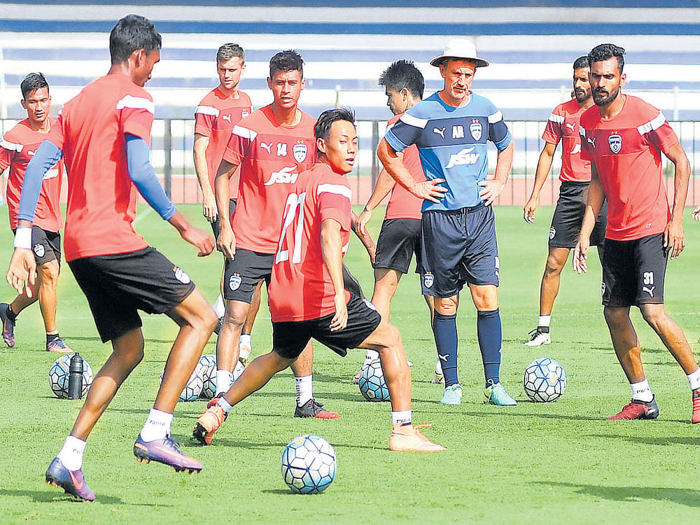training hard: Bengaluru FC players train under the watchful eyes of coach Albert Roca (in hat) ahead of their opening               I-League clash against Shillong Lajong at the Sree Kanteerava Stadium on Saturday. DH PHOTO/ KISHOR kumar bolar