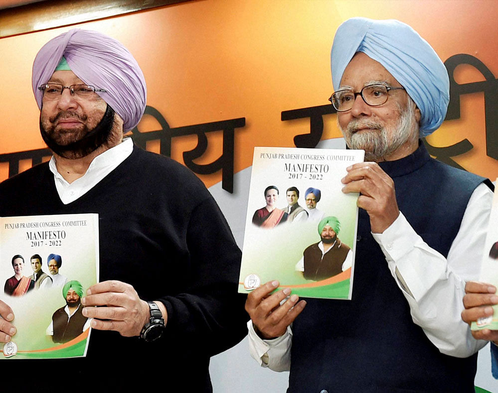 Former Prime Minister Manmohan Singh with Punjab Congress president Capt Amrinder Singh releases the Congress manifesto for the assembly elections in Punjab, at AICC Headquaters in New Delhi on Monday. PTI Photo
