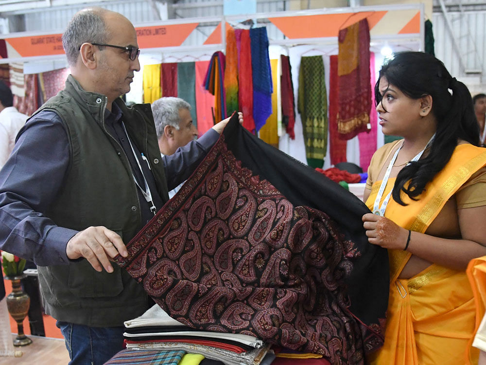 A delegate enquires about a shawl at the Jammu and  Kashmir stall at Pravasi Bharatiya Divas. DH photo