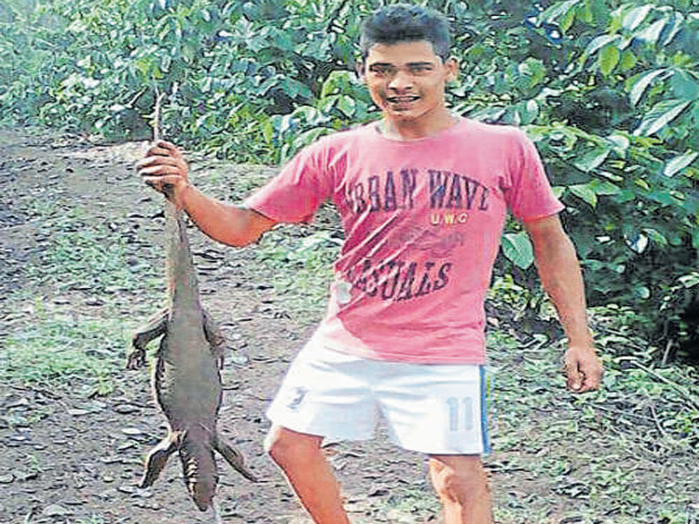 A suspect poses with the carcass of the lizard.