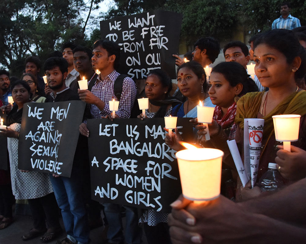 Members of womens' organisations hold a candlelight vigil on Brigade Road on Tuesday to protest against the molestation incident on the night of December 31. DH Photo