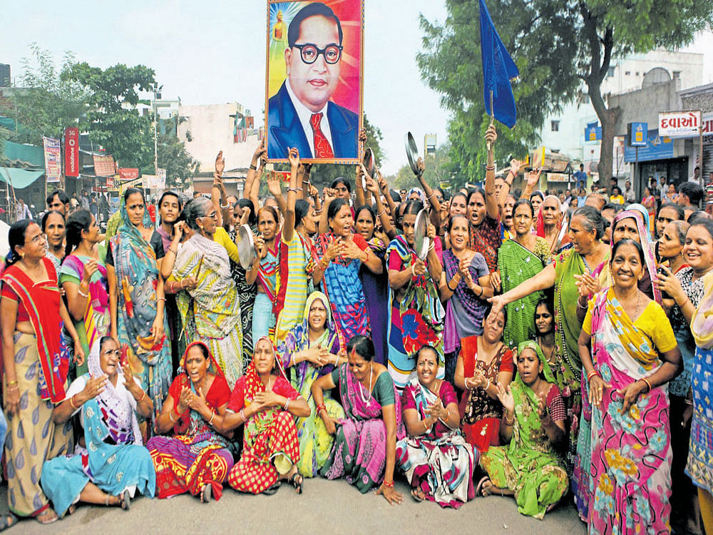 raising their voice: Dalit women in Ahmedabad carry a portrait of Ambedkar as they protest against the assault on four Dalit men by cow vigilantes in Rajkot, Gujarat in July last year. A Dalit rights organisation, Navsarjan Trust, played a leading role in these protests.  pti