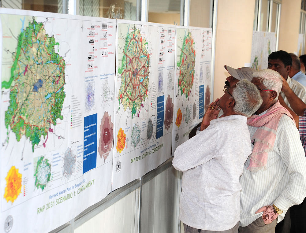 People look at the maps at the public consultation on preparation of revised master plan 2031 for Bengaluru jointly organised by the BDA and the BBMP on Thursday. DH PHOTO
