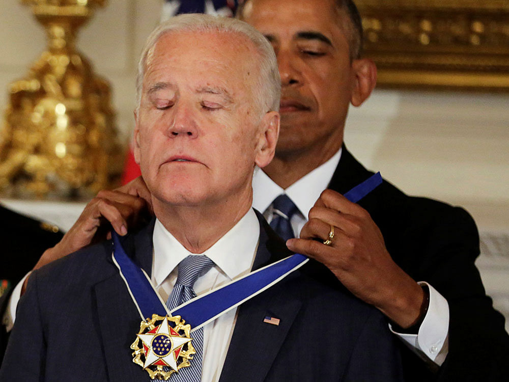 U.S. President Barack Obama presents the Presidential Medal of Freedom to Vice President Joe Biden in the State Dining Room of the White House in Washington, U.S., January 12, 2017. REUTERS