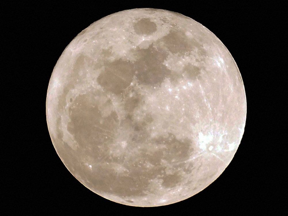 Full moon is seen over the sky of New Delhi on Thursday. Israeli scientists believe that multiple collisions to an early Earth occurred, making a bunch of mini moons which eventually merged together. PTI Photo