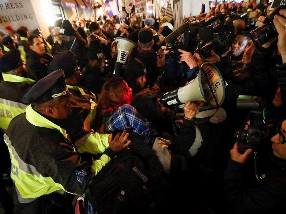 Protestors scuffle with police after refusing to vacate the sidewalk in front of the National Press Club Building ahead of the presidential inauguration in Washington. AP/PTI Photo