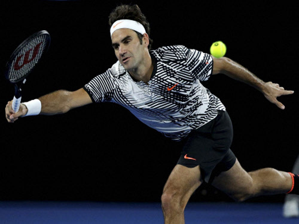 Switzerland's Roger Federer hits a forehand return to Tomas Berdych of the Czech Republic during their third round match at the Australian Open tennis championships in Melbourne, Australia, Friday. AP/PTI