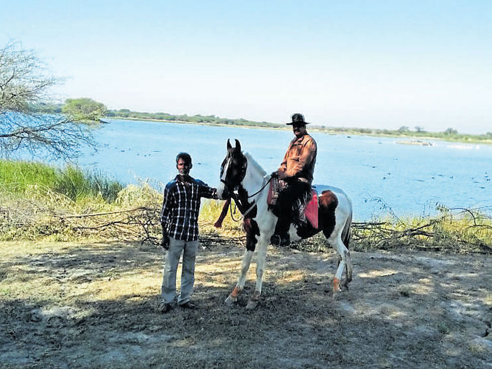 A Pakshi Mitra with his horse and birdwatcher at Kishan Kareri in Rajasthan.