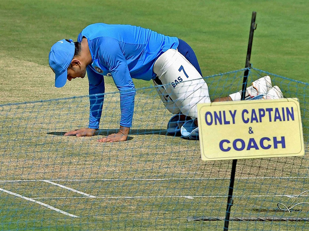 Indian wicket keeper M.S.Dhoni inspecting the pitch during the practice session ahead of the 3rd ODI against England at Eden Garden in Kolkata on Saturday. PTI Photo