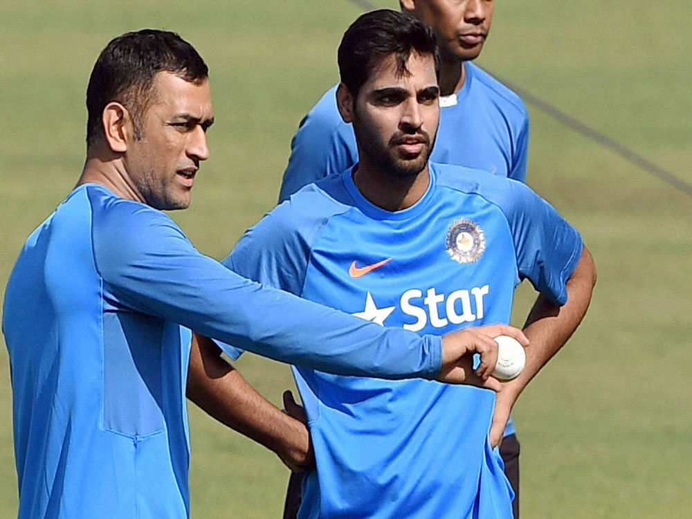 Indian Cricketer M.S.Dhoni giving tips to bowler Bhuvneswar Kumar during a training session ahead of the 3rd ODI Match against England at Eden Garden in Kolkata on Saturday. PTI Photo