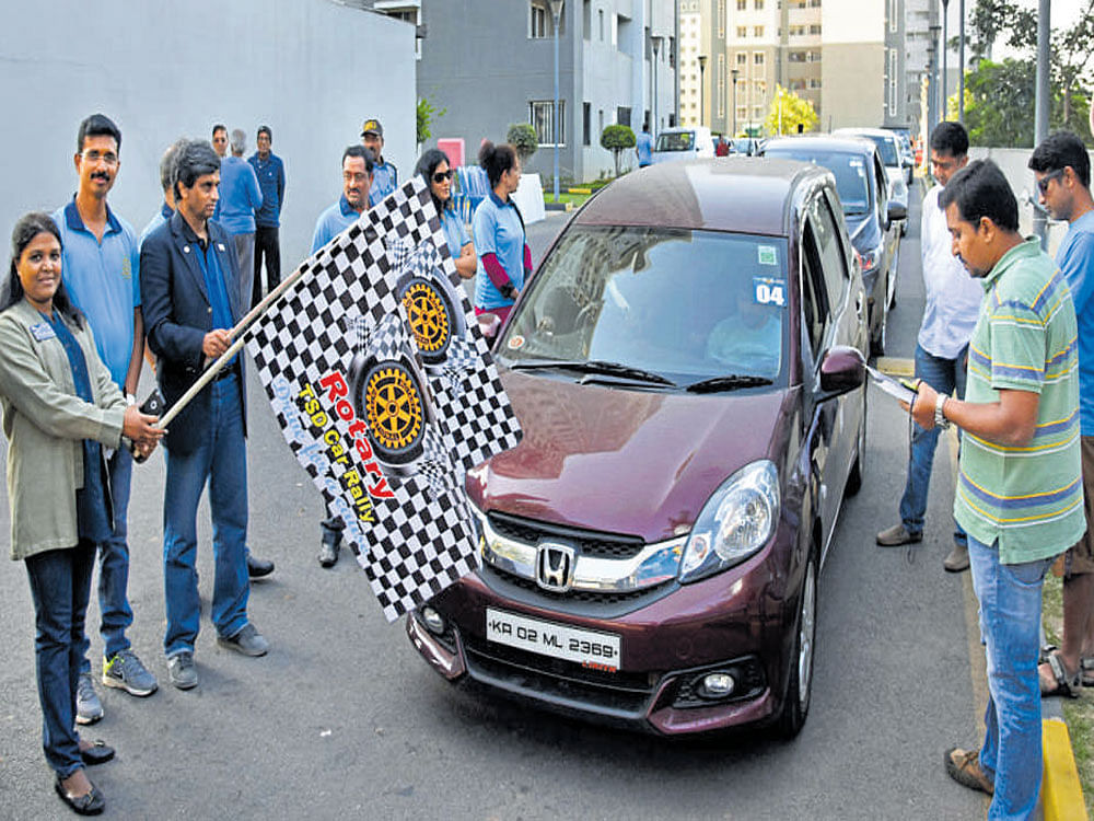 Rotarians Rajendra Rai and Ambika K Narayan flag off the car rally at Nagasandra on Sunday. dh photo