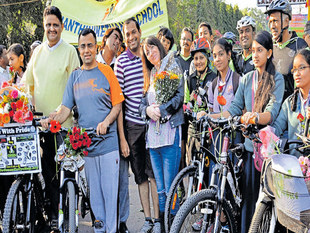 Alyia Phelps-Gardiner (centre), great granddaughter of horticulturist Gustav Hermann Krumbiegel, takes part in a floral bicycle ride in the city on Sunday. School children and volunteers of a few NGOs accompanied her. DH PHOTO